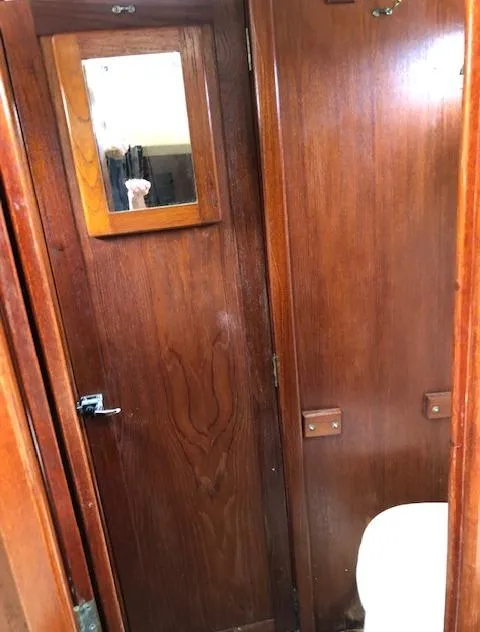 Slide: The Image of 1983 Cape Dory 28 interior with wooden paneling and a small mirror. - 32