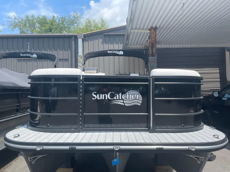 Slide: The Image of 2024 SunCatcher Select 324RC pontoon boat in storage facility. - 2