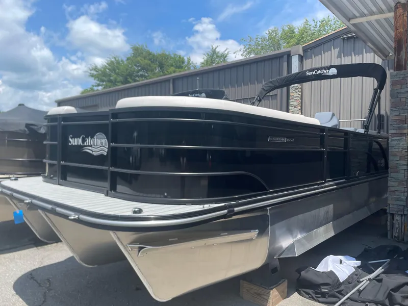 Slide: The Image of 2024 SunCatcher Select 324RC pontoon boat in black, docked outdoors. - 3