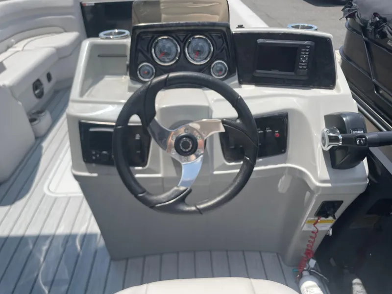 Slide: The Image of 2024 SunCatcher Select 324RC boat dashboard with steering wheel, gauges, and controls. - 8