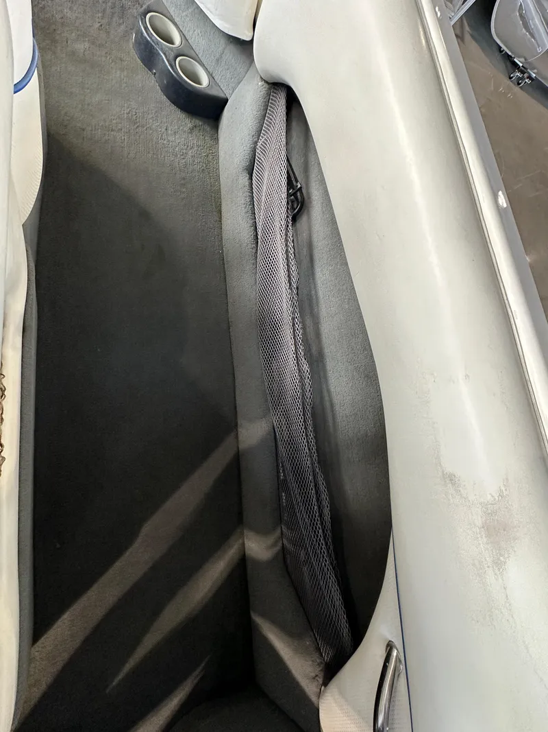 Slide: The Image of 2003 Malibu Wakesetter 23 XTi interior with cup holders and storage compartment. - 11