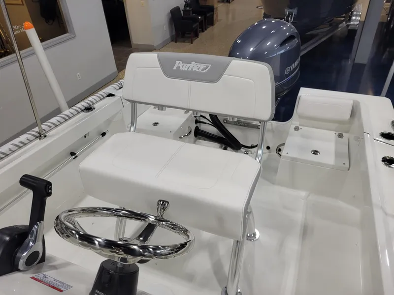 Slide: The Image of 2025 Parker 18 SE CC boat interior with steering wheel and Yamaha engine. - 10