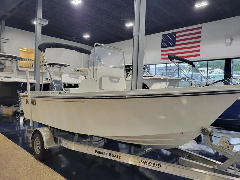 Slide: The Image of 2025 Parker 18 SE CC boat on trailer in showroom with American flag. - 16
