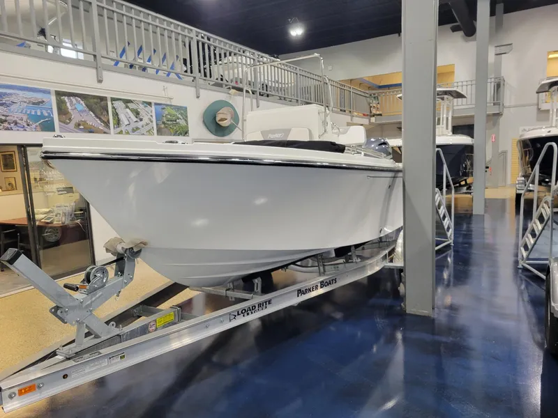 Slide: The Image of 2025 Parker 18 SE CC boat on display in showroom, mounted on trailer. - 6