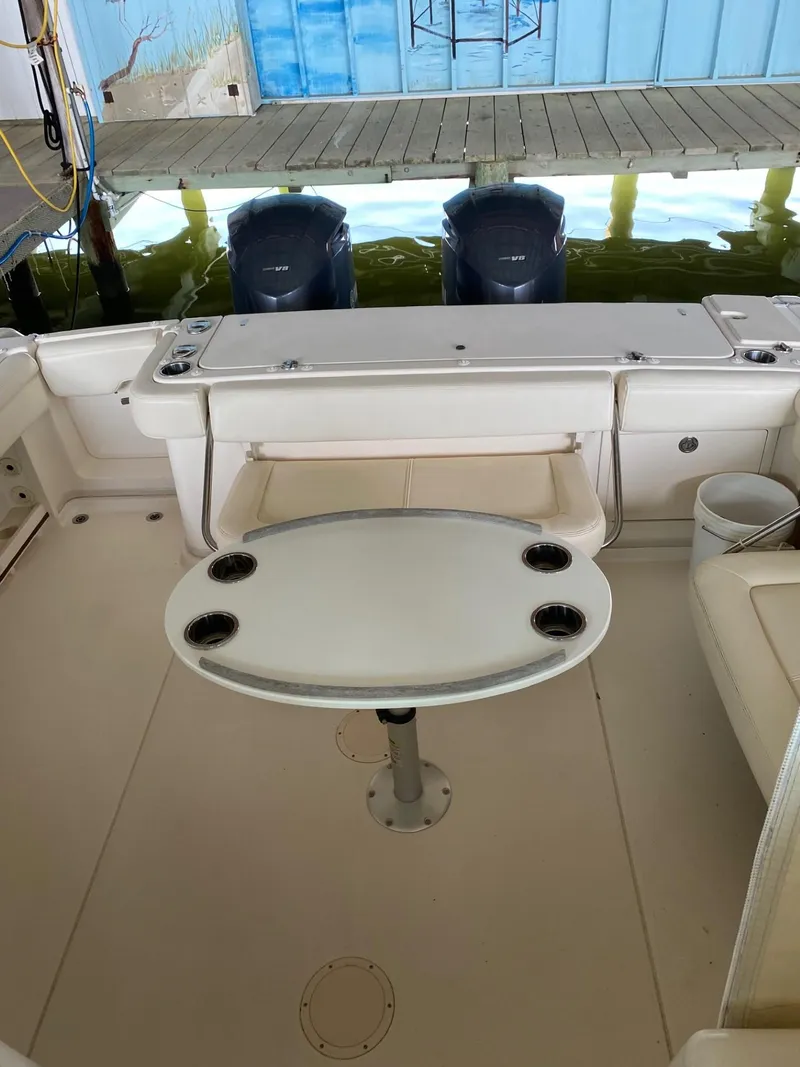 Slide: The Image of 2016 Grady-White 33 Express boat interior with table and twin outboard engines. - 16