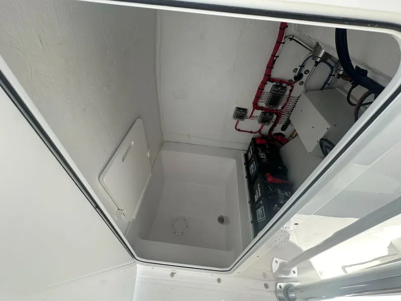 Slide: The Image of 2025 Blue Water 23T CC boat electrical compartment with batteries and wiring. - 8