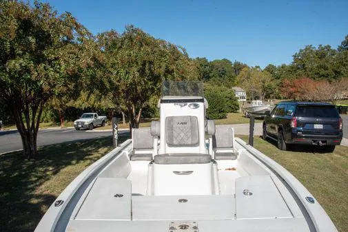 Slide: The Image of 2024 Avid 21 FSX boat parked on a grassy area with trees and vehicles. - 11