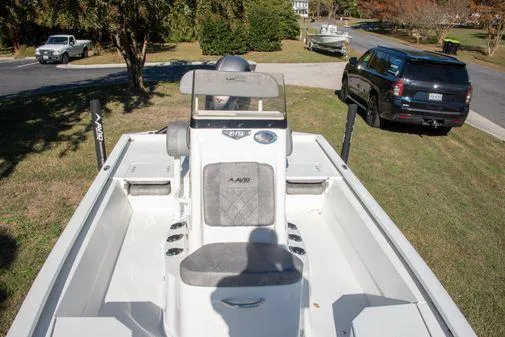 Slide: The Image of 2024 Avid 21 FSX boat parked on grass with vehicles in the background. - 21