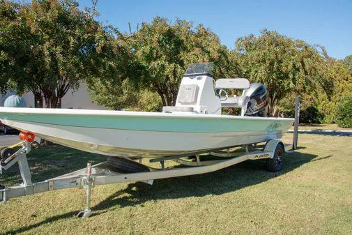 Slide: The Image of 2024 Avid 21 FSX boat on trailer in grassy area. - 23