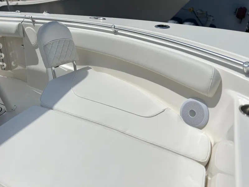 Slide: The Image of 2025 Key West 244 CC boat interior with white cushioned seating and speaker. - 23