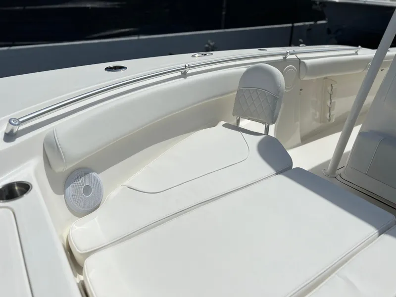 Slide: The Image of 2025 Key West 244 CC boat interior with white cushioned seating and speaker. - 24