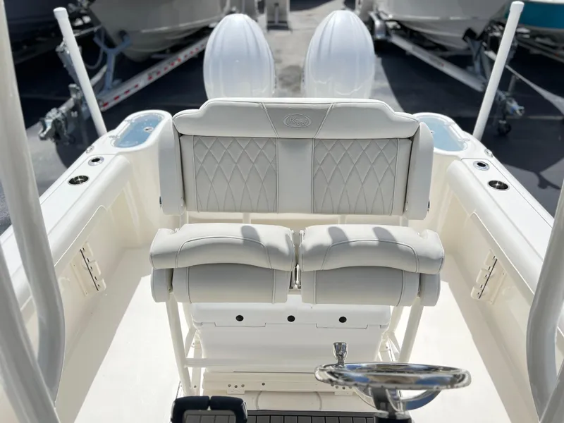 Slide: The Image of 2025 Key West 244 CC boat interior with white cushioned seating and steering wheel. - 31