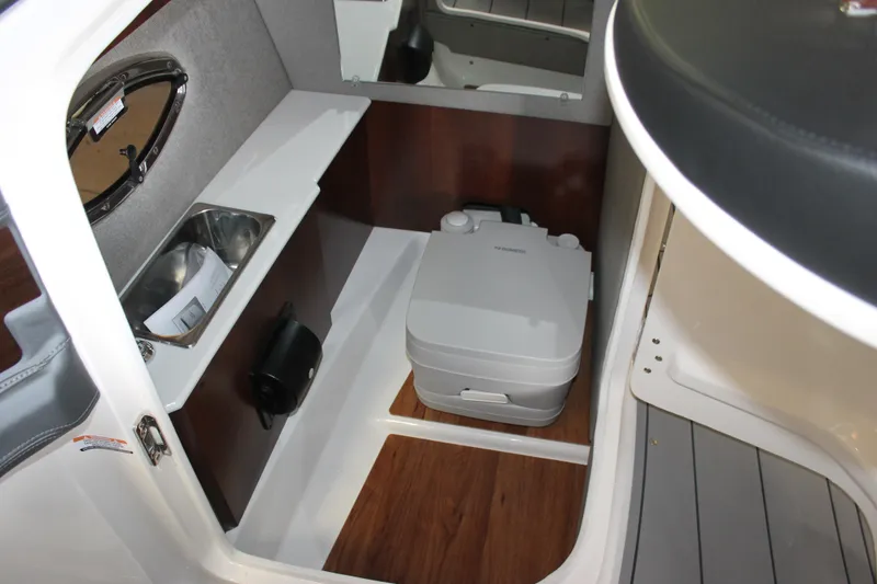Slide: The Image of 2020 Chaparral 257 SSX boat interior with compact toilet and sink. - 9
