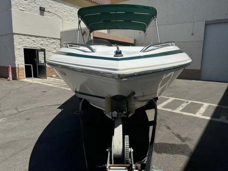 Slide: The Image of 2001 Cobalt 25 LS boat with green canopy on trailer in parking lot. - 2