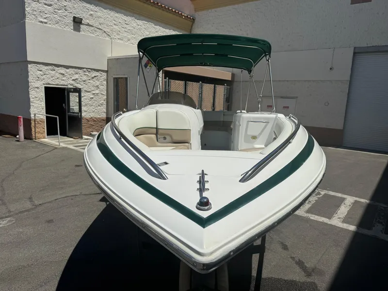 Slide: The Image of 2001 Cobalt 25 LS boat with green canopy in a parking lot. - 3