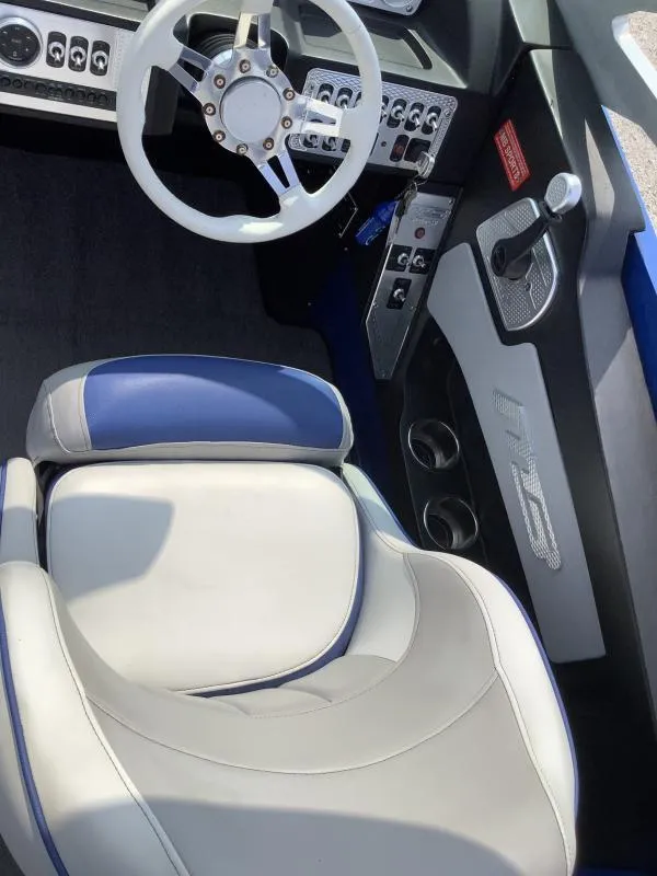 Slide: The Image of 2016 MB B52 23 boat interior with white and blue seats and steering wheel. - 19