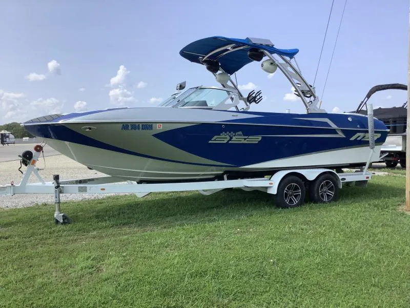 Slide: The Image of 2016 MB B52 23 boat on trailer, blue and white, parked on grass. - 4