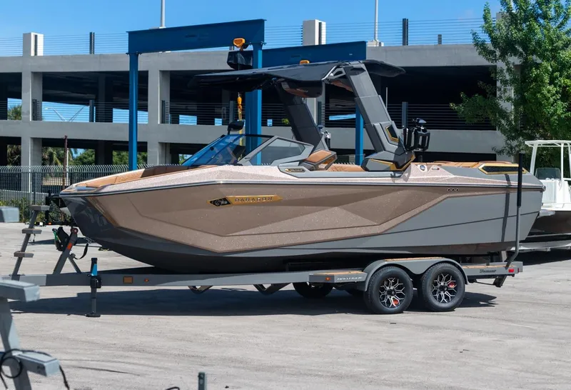 Slide: The Image of 2024 Nautique G23 boat on a trailer in a parking lot. - 10