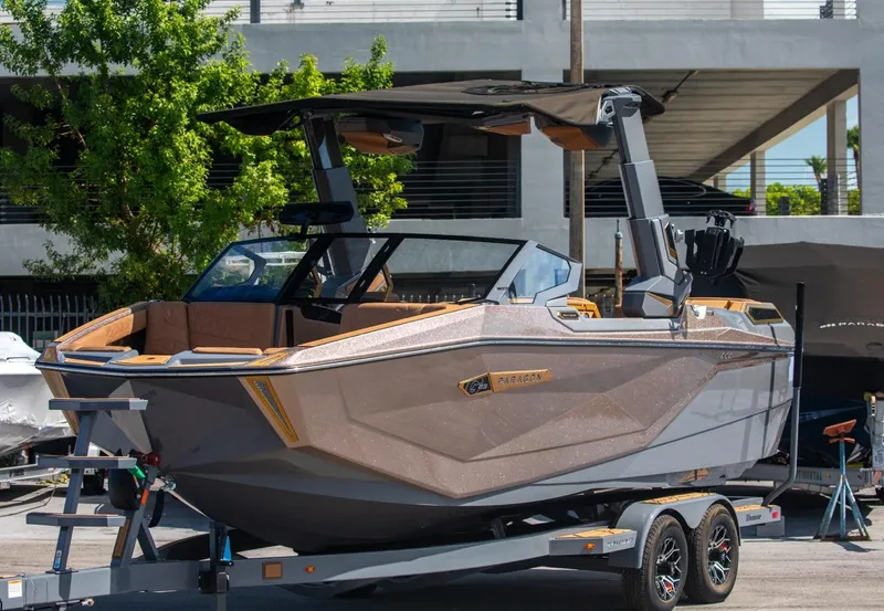 Slide: The Image of 2024 Nautique G23 boat on trailer, docked outdoors. - 11