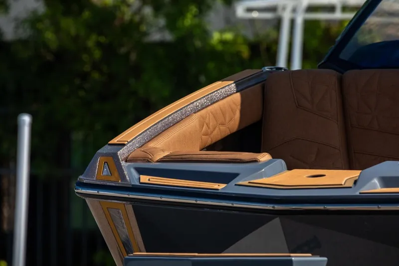 Slide: The Image of 2024 Nautique G23 boat with luxurious brown seating and sleek design. - 12
