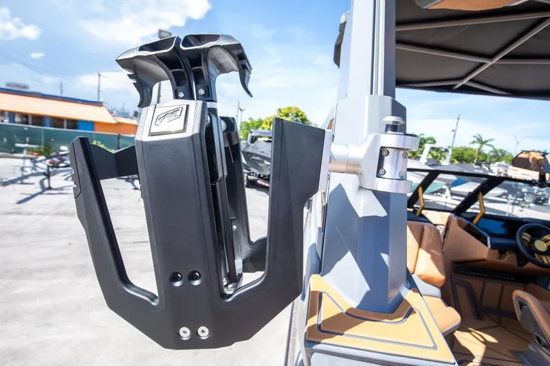 Slide: The Image of 2024 Nautique G23 boat with wakeboard rack in sunny outdoor setting. - 22