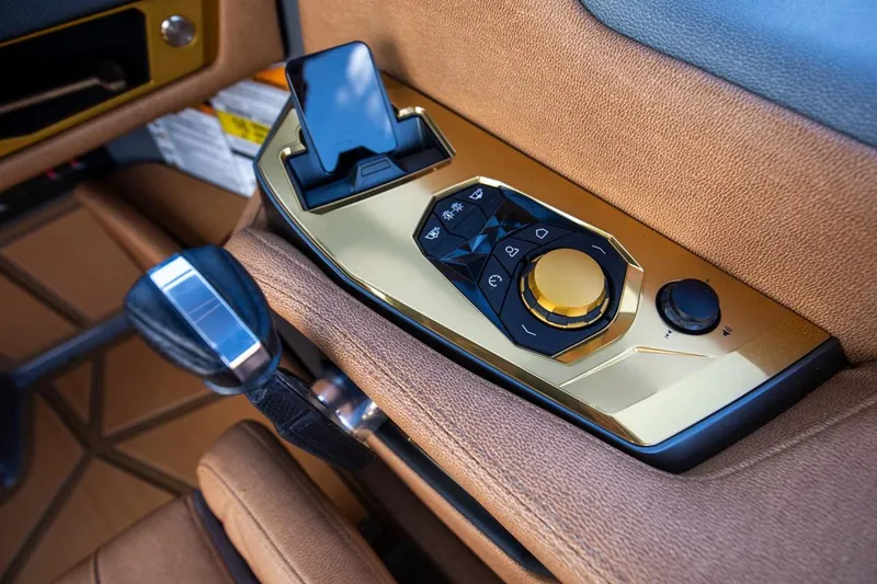 Slide: The Image of 2024 Nautique G23 boat control panel with gold accents and ergonomic design. - 23