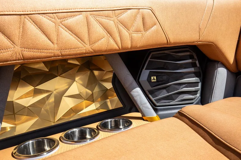 Slide: The Image of 2024 Nautique G23 interior with luxurious tan upholstery and modern speaker system. - 30