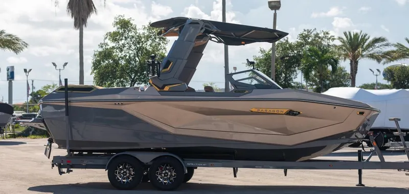 Slide: The Image of 2024 Nautique G23 boat on a trailer in a sunny outdoor setting. - 4