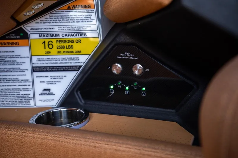 Slide: The Image of 2024 Nautique G23 boat control panel and capacity warning labels. - 40