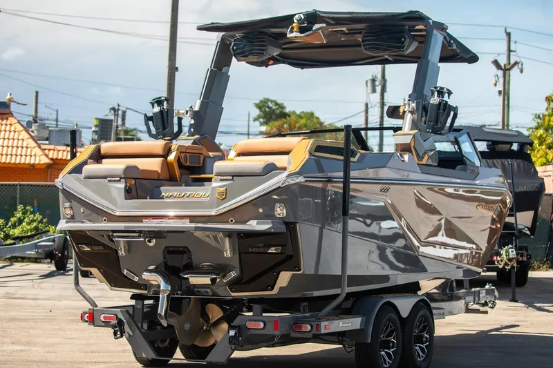 Slide: The Image of 2024 Nautique G23 boat on trailer, rear view, outdoor setting. - 5