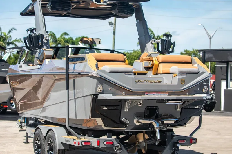 Slide: The Image of 2024 Nautique G23 boat on trailer, rear view, outdoor setting. - 6
