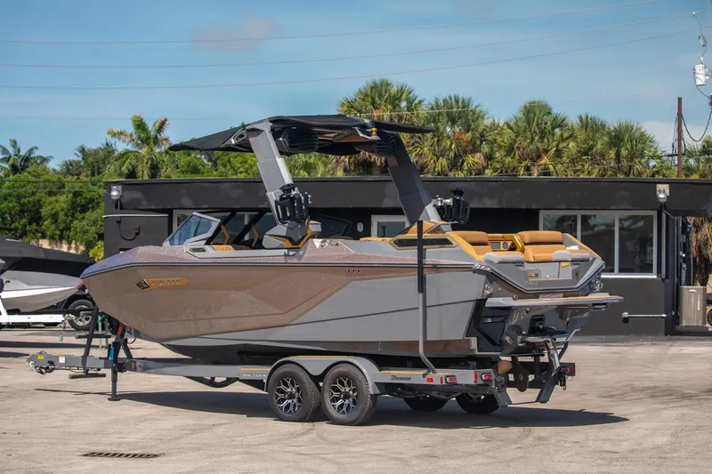 Slide: The Image of 2024 Nautique G23 boat on a trailer in a marina. - 7