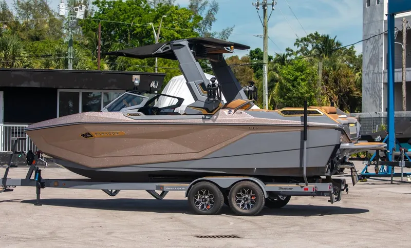 Slide: The Image of 2024 Nautique G23 boat on a trailer in a marina. - 9