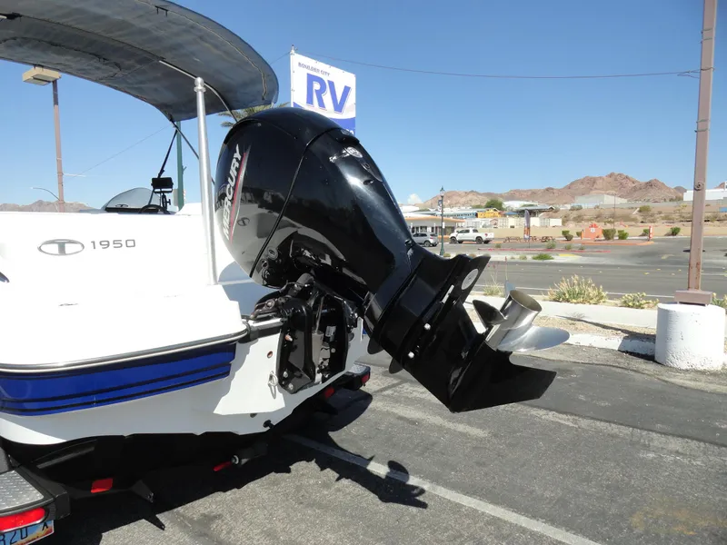 Slide: The Image of Tahoe 1950 boat with Mercury outboard motor, parked near an RV dealership, 2020 model. - 23