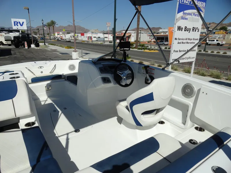 Slide: The Image of 2020 Tahoe 1950 boat interior with steering wheel and seating, parked at dealership. - 6