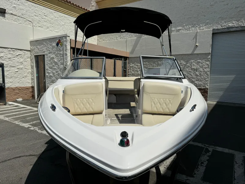 Slide: The Image of 2019 Regal 1900 ES Bowrider boat with beige seating and black canopy. - 4