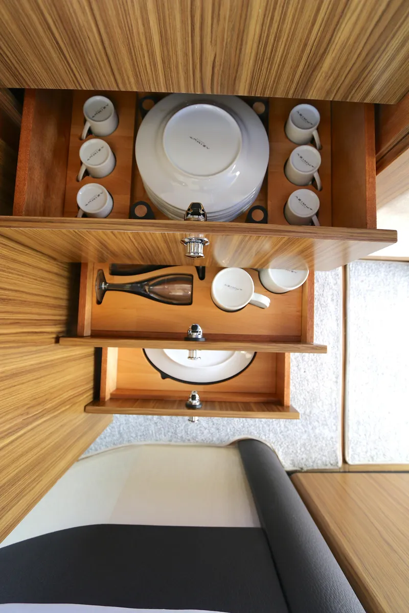 Slide: The Image of Azimut Magellano 43 yacht interior, 2014 model, featuring organized wooden drawers with dishes and cups. - 13