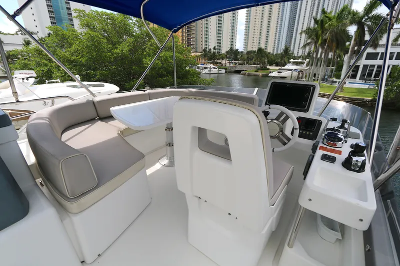 Slide: The Image of 2014 Azimut Magellano 43 yacht helm with seating, controls, and waterfront view. - 21