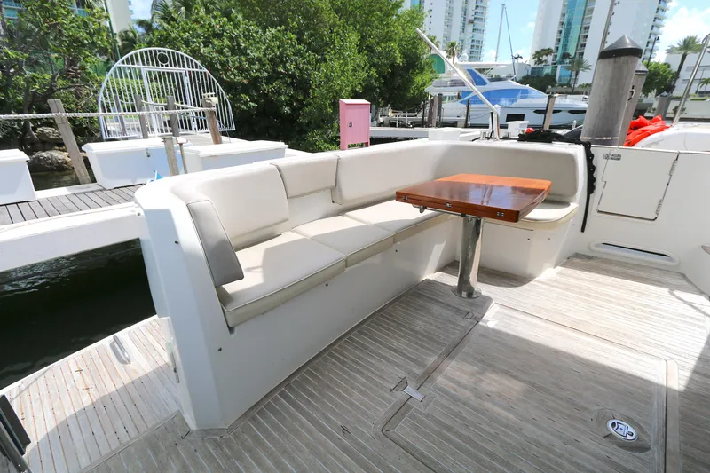 Slide: The Image of Outdoor seating area on 2014 Azimut Magellano 43 yacht, featuring a wooden table and cushioned bench. - 24