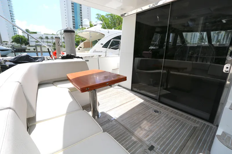 Slide: The Image of 2014 Azimut Magellano 43 yacht deck with seating and table, docked in marina. - 25