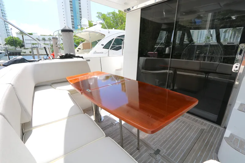 Slide: The Image of Luxurious 2014 Azimut Magellano 43 yacht with elegant outdoor seating and polished wooden table. - 26