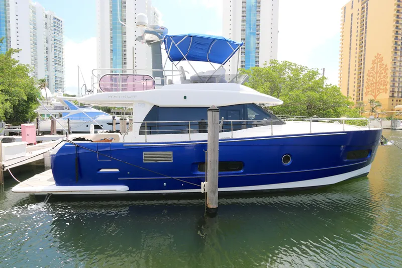 Slide: The Image of 2014 Azimut Magellano 43 yacht docked in a marina, surrounded by tall buildings. - 29