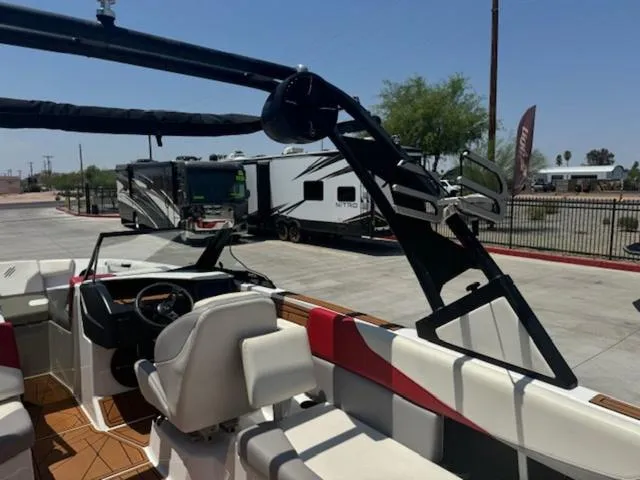 Slide: The Image of 2020 ATX Boats 24 TYPE-S interior with white and red seating, parked near RVs. - 15