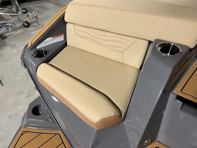 Slide: The Image of 2025 Nautique Super Air Nautique G23 boat seat with beige upholstery and cup holders. - 11