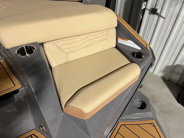 Slide: The Image of 2025 Nautique Super Air Nautique G23 boat with beige seating and cup holders. - 12