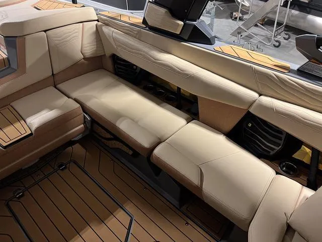 Slide: The Image of 2025 Nautique Super Air Nautique G23 interior seating with beige upholstery and teak accents. - 17