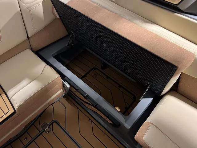 Slide: The Image of 2025 Nautique Super Air Nautique G23 interior storage compartment with beige and brown seating. - 18