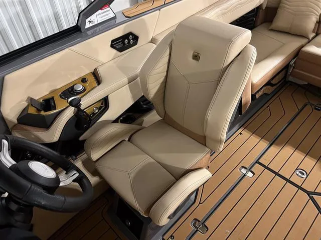 Slide: The Image of 2025 Nautique Super Air Nautique G23 boat interior with beige captain's chair and modern dashboard. - 20