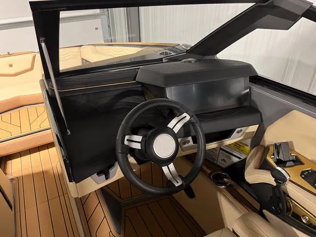 Slide: The Image of 2025 Nautique Super Air Nautique G23 boat interior, featuring a modern steering wheel and dashboard. - 21