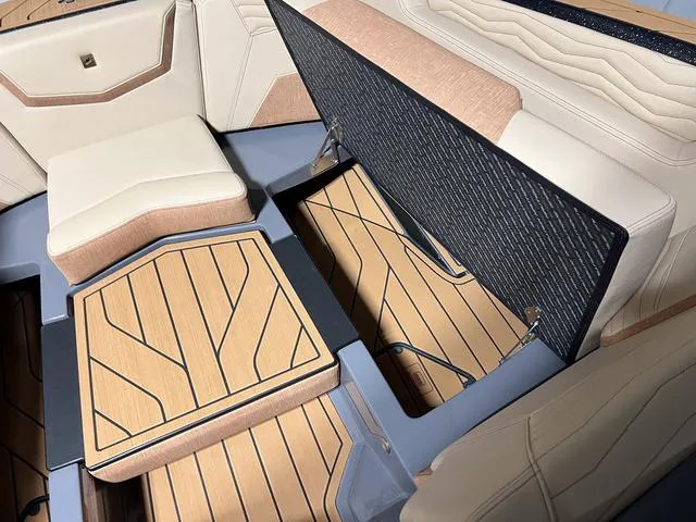 Slide: The Image of 2025 Nautique Super Air Nautique G23 interior with open storage compartments and teak flooring. - 32
